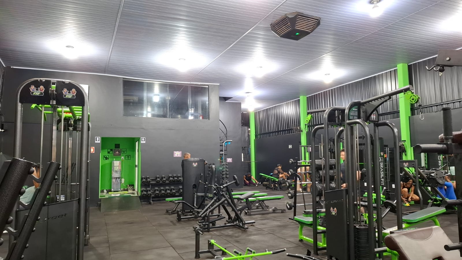 Área de musculação com máquinas, bancos e halteres